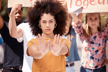 Image showing Protest, hands and stop with a black woman activist in demonstration with a group of people ready to fight for freedom. Community, politics and rally with a young female standing against violence