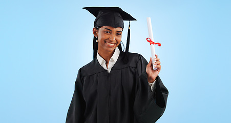 Image showing Graduate woman, diploma and portrait in studio with pride, success and achievement by blue background. Graduation, girl and certificate with award, celebration or learning for future from university