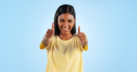 Image showing Woman, happy in portrait and thumbs up for agreement, success or support with hand gesture on blue background. Like, yes and emoji with feedback, vote or opinion in studio with thank you or praise