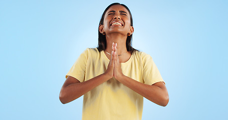 Image showing Woman, praying and worship for faith and religion in studio, guide with help and trust God on blue background. Desperate, anxiety and prayer, sorry or forgiveness with pain, gratitude and spiritual