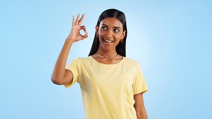 Image showing Woman, OK hand gesture and agreement for success or support with smile and mockup space on blue background. Like, yes and emoji with feedback, vote or opinion in studio with thank you or praise