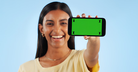 Image showing Cellphone green screen, studio portrait and happy woman show web announcement, mobile info or app chroma key UI. Tracking markers, smartphone mockup space and Indian person face on blue background