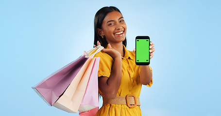 Image showing Smartphone green screen, shopping bag and portrait of happy woman show online shop, retail market or studio omnichannel. Tracking markers, phone chroma key or mockup space customer on blue background