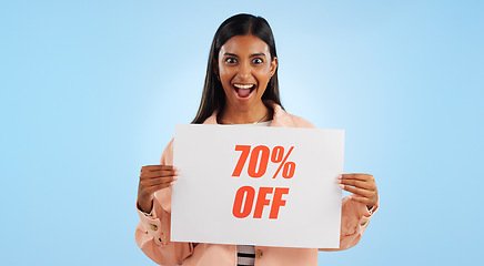 Image showing Woman, promotion poster and portrait with sale, discount and billboard in studio. Excited, smile and happy from savings and deal paper with banner and promo with blue background and price decrease