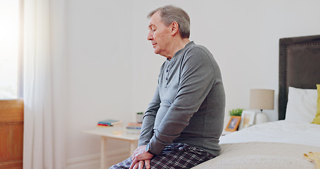 Image showing Senior man, thinking and lonely in bedroom with depression, anxiety or mental health in retirement. Tired, elderly person and remember grief or loss in morning, home or sad in the house with a memory