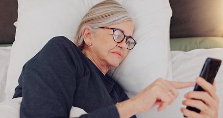 Image showing Phone, relax and senior woman in bed networking on social media, mobile app or internet. Technology, rest and elderly female person in retirement scroll on website with cellphone in bedroom at home.