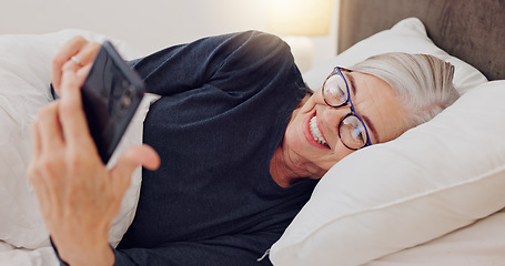 Image showing Senior woman, bed and reading with phone or happy streaming funny, comedy or meme on social media. Elderly person, smile or relax with cellphone at night in bedroom with communication or online chat