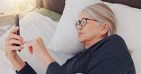 Image showing Phone, relax and elderly woman in bed networking on social media, mobile app or internet. Technology, rest and senior female person in retirement scroll on website with cellphone in bedroom at home.