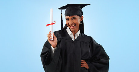 Image showing Graduate woman, certificate and portrait in studio with pride, success and achievement by blue background. Graduation, girl and diploma with award, celebration or paperwork for future from university