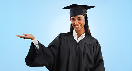 Image showing Graduation student, portrait and happy woman palm gesture for learning news, university info or college study. Studio mockup space, presentation or graduate scholarship opportunity on blue background