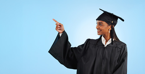 Image showing Graduation student, studio and happy woman point at learning news, university info or college development. Mockup space, promotion and graduate gesture at education opportunity on blue background