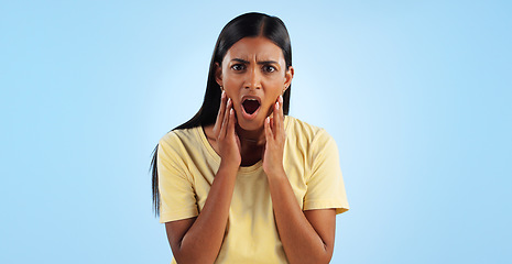Image showing Shock, surprise and woman in portrait in studio with reaction, facial expression and horror on blue background. Open mouth, wow for news or announcement, mockup space and gossip drama with mind blown