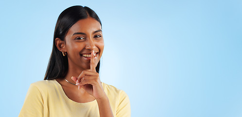 Image showing Secret, portrait and woman with finger on lips, whisper and announcement on a blue background. Person, face or model with privacy, mockup space or drama news with surprise, emoji or gossip with shush