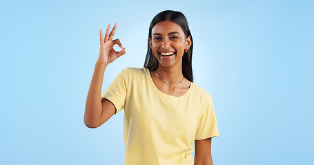 Image showing Happy woman, OK hand gesture and agreement for success or support, smile and mockup space on blue background. Like, yes and emoji with feedback, vote or opinion in studio with thank you or praise
