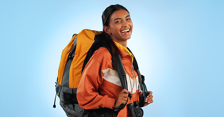 Image showing Hiking studio, backpack and happy woman trekking, backpacking and travel gear for fitness, adventure or tourism holiday. Camping bag, equipment and person smile for trip journey on blue background