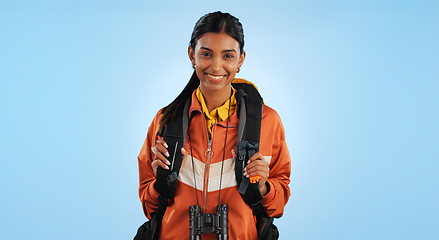 Image showing Hiking studio, portrait and happy woman trekking, backpacking or travel for fitness, adventure or tourism holiday. Active tourist, smile or Indian person vacation, freedom or break on blue background