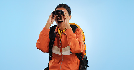 Image showing Hiking journey, binocular and studio woman watch trekking, backpacking or travel adventure view, sightseeing or bird watching. Wow, search discovery and explorer see destination on blue background