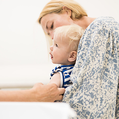 Image showing Child beeing vaccinated by pediatrician in presence of his mother. Preventive vaccination against Diphtheria, whooping cough, tetanus, hepatitis, haemophilus influenzae, pneumococcus, poliomyelitis