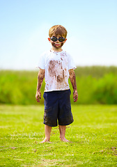 Image showing Child, boy or mud on face with goggles in garden, grass or field for playing, fun and summer weather. Kid, person or eyewear covered in dirt on lawn or backyard for muddy play, childhood or enjoyment