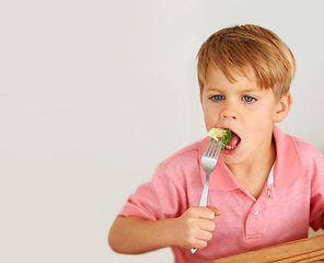 Image showing Child, broccoli or vegetables fork eat for healthy nutrition meal, dinner hunger at kitchen table. Male person, kid and hand wall background or fibre lunch for development, youth or organic taste