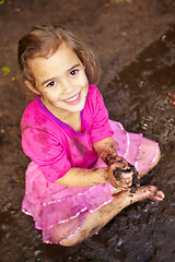 Image showing Girl, child and portrait with smile in mud for freedom, playing and muddy fun in sunshine weather or outdoor. Kid, female and face of person with happiness for activity, enjoyment and relax in dirt