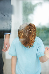 Image showing Sad, child and home by window to play outside, anxiety and lonely for fear, conflict and trauma in family. Young, boy and depression for stay indoor, glass or mental health for balance childhood