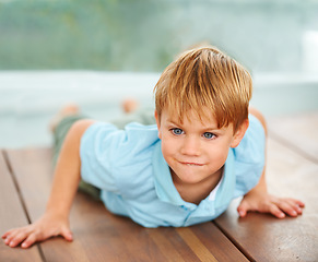 Image showing Child, looking and playing game on floor in family home, kindergarten and ready for action at object. Usa boy,.happiness and play in living room to relax, fun and joy in youth and vacation house