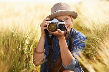 Image showing Field, photographer and woman with a camera, portrait with nature, travel and memory with sunshine. Person, countryside or face with photography, outdoor and journey with adventure, picture or summer