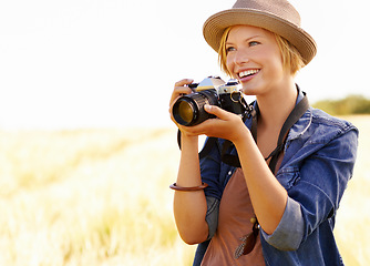 Image showing Field, photographer and woman with a camera, adventure and thinking with ideas, nature and memory. Person, countryside and girl with photography, tourism and journey with sunshine, smile and travel