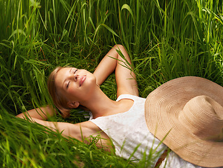 Image showing Nature field, grass and relax woman sleeping, tired or nap for outdoor sunshine, morning wellness or rest. Forest garden, woods or eco person dream, spring comfort or park break on natural green lawn