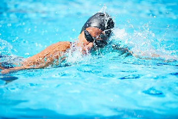 Image showing Splash, swimming and pool with a sports woman for training, cardio workout or exercise for fitness. Female athlete person or professional swimmer in clear blue water for competition in swimsuit