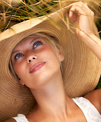 Image showing Wheat, hat and relax with woman in field for travel, vacation and holiday. Thinking, peace and nature with female person and grass in countryside meadow for calm environment, spring and sunshine