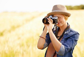 Image showing Woman, camera and photography with safari, vacation and holiday with wheat field and plants. Nature, photographer and outdoor with traveler blog and countryside with photo for adventure and journey