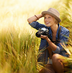 Image showing Woman, camera and photography with happy travel, vacation and holiday with wheat field and plants. Nature, photographer and outdoor with blog and countryside with photo for adventure and journey