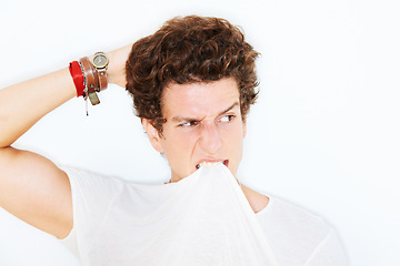 Image showing Thinking, confused and a man biting his tshirt in studio isolated on white background for crazy style. Face, doubt or expression with a young model scratching his head, looking clueless about an idea