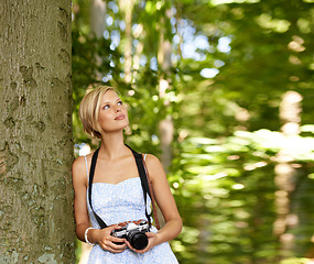 Image showing Thinking, trees and photography with woman in forest for relax, memory and travel photography. Summer, nature and adventure with person and camera for vacation, holiday and environmental tourism