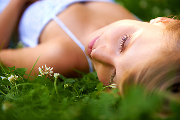 Image showing Spring, sleeping and relax with woman on grass in nature for calm, park and peace. Holiday, flowers and field with face of female person lying in countryside meadow for summer, vacation and wellness