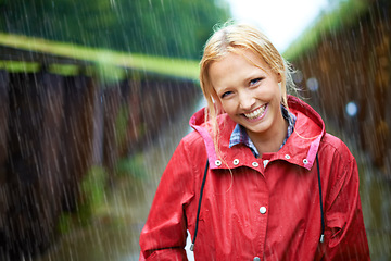 Image showing Woman, smile and raincoat in outdoor storm, wet and cold from weather, winter and nature. Happy female person, fashion and red jacket is cool, rainfall and protection from water, face and travelling