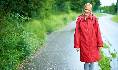 Image showing Woman, smile and raincoat in outdoor rain, wet and cold from weather, winter and nature. Happy female person, road and red jacket is trendy, rainfall and protection from water, face and holiday