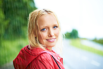 Image showing Happy, portrait and young woman in the rain with coat in nature, road or street for winter. Smile, positive attitude and female person from Australia in drizzle or storm weather in outdoor forest.