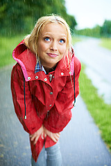 Image showing Woman, rain and raincoat in nature, thinking and cold from weather, winter and outdoors. Female person, wet and red coat for fashion on trip, rainfall and protection from water, vacation and holiday