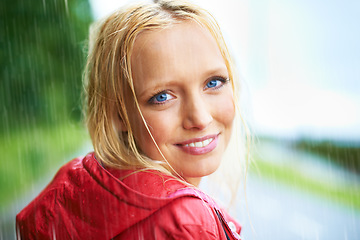 Image showing Happy, smile and young woman in the rain with coat in nature, road or street for winter. Portrait, positive attitude and female person from Australia in drizzle or storm weather in outdoor forest.