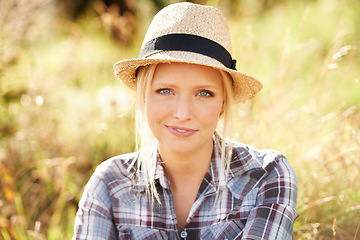 Image showing Happy, portrait and young woman in nature with a straw hat sitting in an outdoor garden for fresh air. Smile, fashion and female person from Australia in the forest, woods or field with casual style.