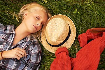 Image showing Woman, sleep and rest on grass in nature to relax, peace and calm on field, outdoors and spring. Female person, eyes closed and nap on plants, dream and fashion on holiday, meadow and vacation