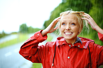 Image showing Woman, smile and raincoat or hands in storm, wet and cold from weather, winter and nature. Happy female person, fashion and red jacket is trendy, rainfall and protection from water, face and playful