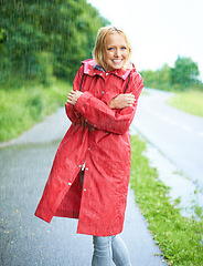 Image showing Raining, portrait and young woman with coat in nature, road or street for winter in countryside. Smile, positive attitude and female person from Canada in drizzle or storm weather in outdoor forest.