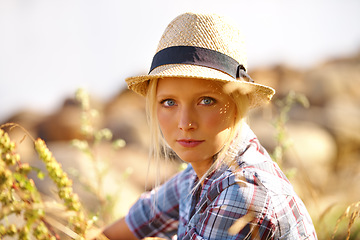 Image showing Serious, portrait and young woman in nature with straw hat sitting in outdoor garden for fresh air. Beautiful, fashion and female person from Australia in the forest, woods or field with casual style