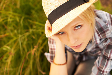 Image showing Nature, portrait and young woman with straw hat sitting in an outdoor garden for fresh air. Serious, fashion and female person from Australia in the forest, woods or field with casual style.
