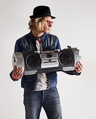 Image showing Boombox, fashion and retro style of a man in studio with music, radio or audio sound and noise. Male model person on a white background with denim outfit, glasses and hipster hat to listen to song