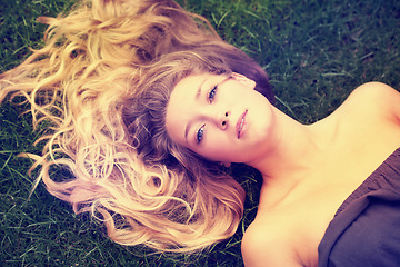 Image showing Portrait, hair and a woman on the grass from above to relax in nature during summer for freedom. Face, beauty and a girl in the park, lying on a field outdoor to rest on a green background alone